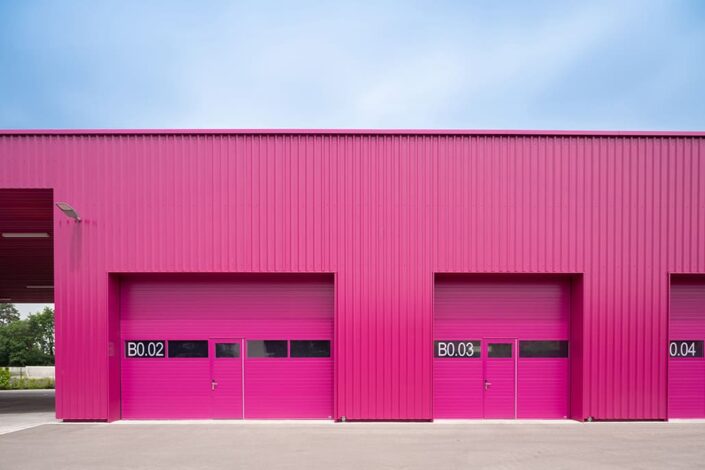 Frontale Ansicht des pinkfarbenen Garageninneren, Bauhof Unterföhring, Architekten Knerer und Lang, Kunde Morgenstern & Kaes, Foto von Mathis Beutel Architekturfotografie