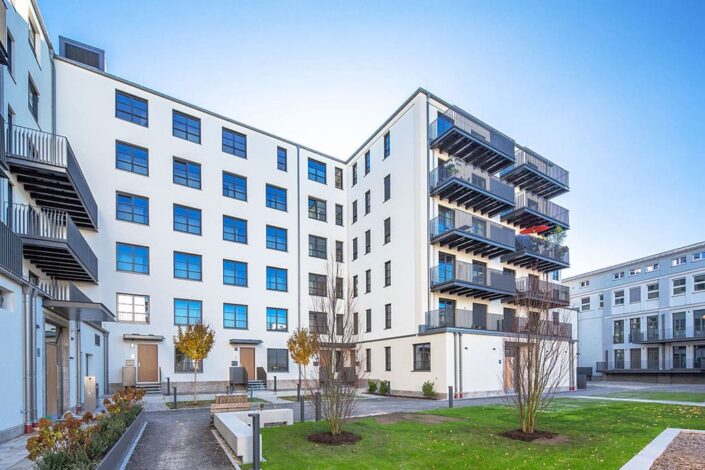 Ansicht vom Hof mit Wiese im Vordergrund, Wohnhaus Tölzer Str./Portenstraße, Kunde Maier Immobilien, Foto von Mathis Beutel Architekturfotografie